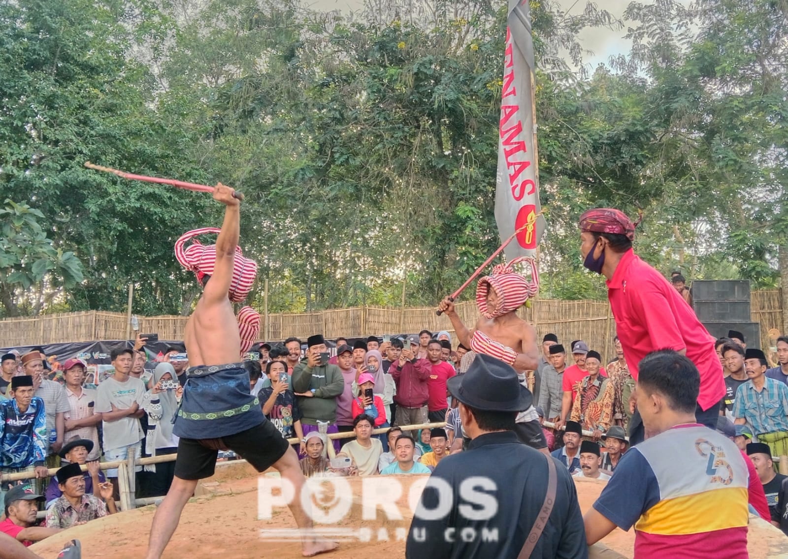 Momen saat dua pertarung Ojhung mengayunkan rotan di atas kepala.