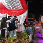 Wakil Bupati Sumenep KH. Imam Hasyim melepas keberangkatan jamaah haji 2026 kloter 77 sembari melambaikan tangan di GOR A. Yani Pangligur.