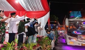 Wakil Bupati Sumenep KH. Imam Hasyim melepas keberangkatan jamaah haji 2026 kloter 77 sembari melambaikan tangan di GOR A. Yani Pangligur.