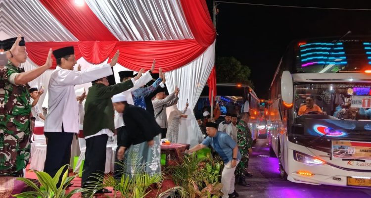 Wakil Bupati Sumenep KH. Imam Hasyim melepas keberangkatan jamaah haji 2026 kloter 77 sembari melambaikan tangan di GOR A. Yani Pangligur.