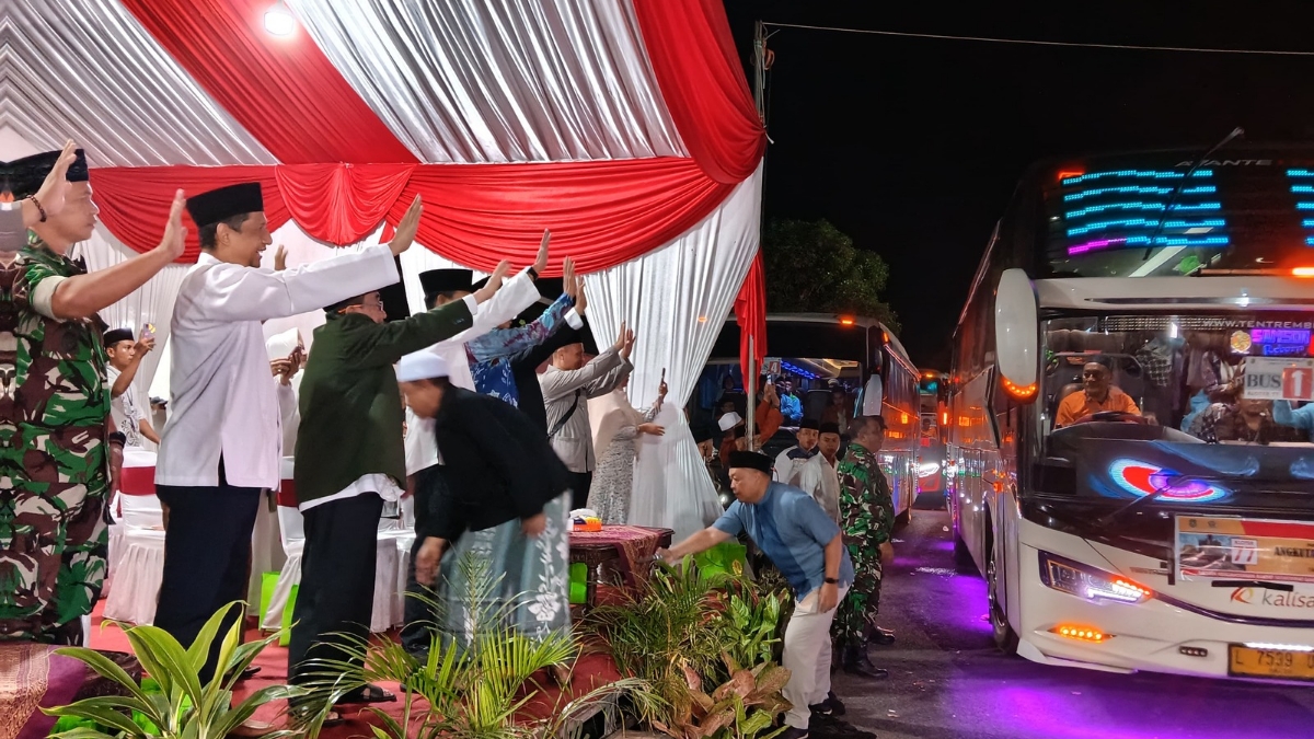 Wakil Bupati Sumenep KH. Imam Hasyim melepas keberangkatan jamaah haji 2026 kloter 77 sembari melambaikan tangan di GOR A. Yani Pangligur.