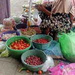 Pedagang sayuran di Pasar Anom Baru Sumenep tengah menjajal dagangannya.