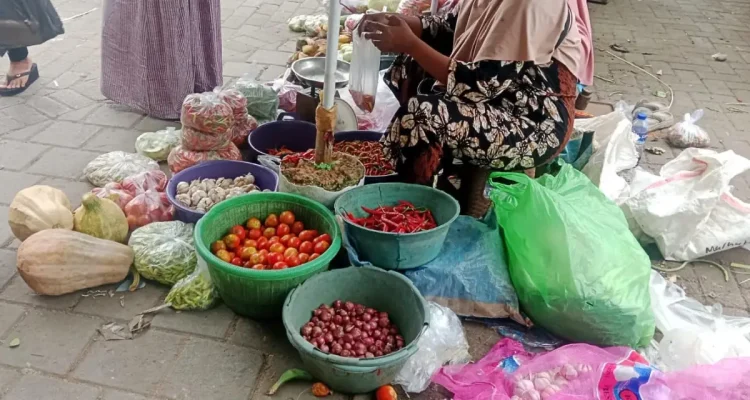 Pedagang sayuran di Pasar Anom Baru Sumenep tengah menjajal dagangannya.