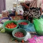 Pedagang sayuran di Pasar Anom Baru Sumenep tengah menjajal dagangannya.