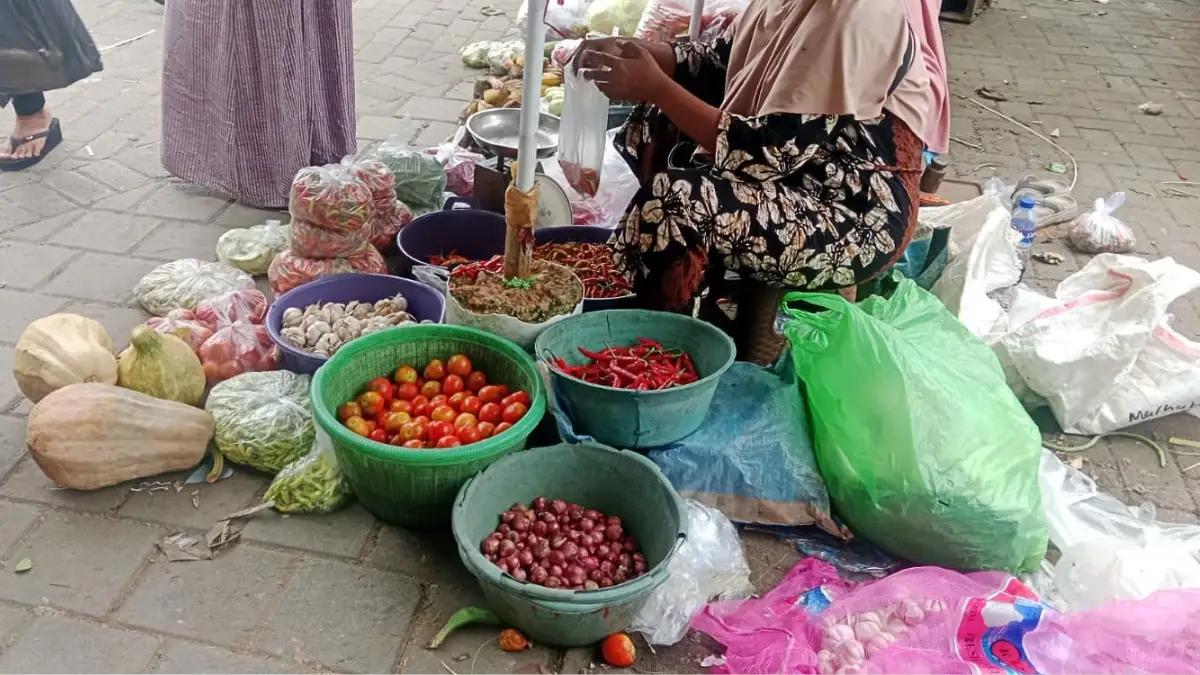 Pedagang sayuran di Pasar Anom Baru Sumenep tengah menjajal dagangannya.